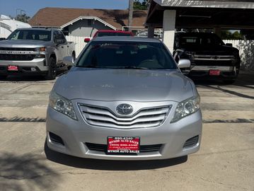 Front view of a silver Toyota sedan parked outdoors at a car dealership.