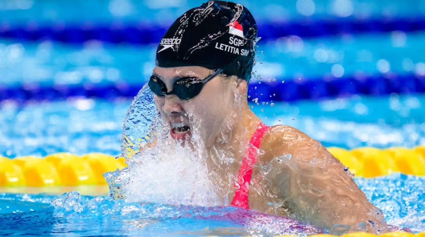 Swimmer in action, breathing amidst splashing water.