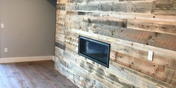 Modern room with a rustic wooden accent wall and a built-in fireplace.