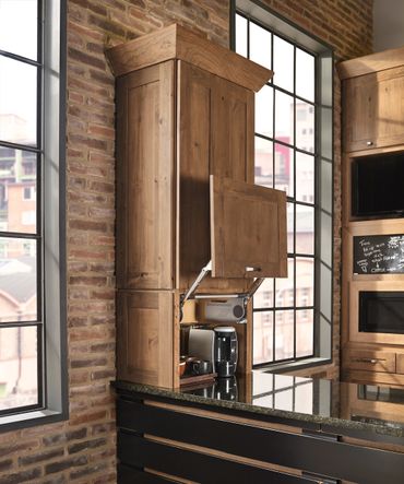 Wooden kitchen cabinet with a lift-up door revealing appliances inside.