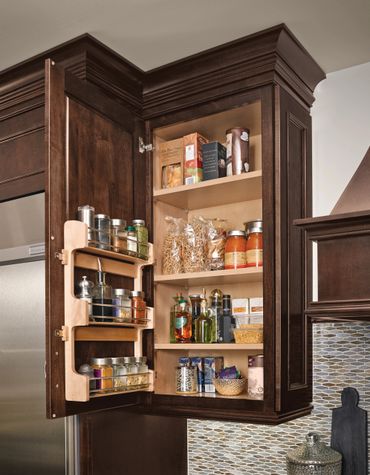 Organized kitchen pantry cabinet with spices, pasta, and sauces.