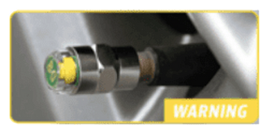 Close-up of a metal valve with a yellow warning sign.