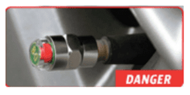 Close-up of a metal valve with a red danger label.