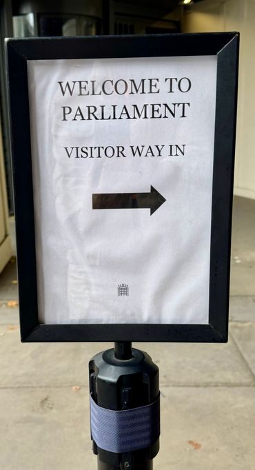 Sign directing visitors to the entrance of Parliament.
