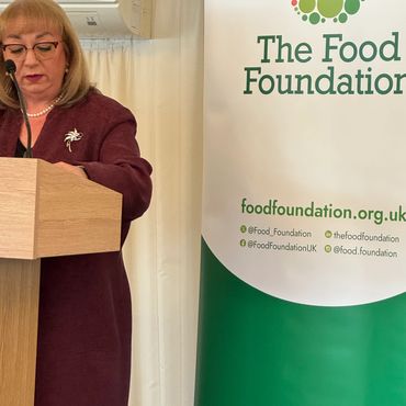 Woman speaking at a podium beside The Food Foundation banner.
