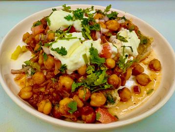 Chole bhature garnished with fresh coriander and yogurt.