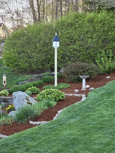 Farmhouse birdhouse in a garden
