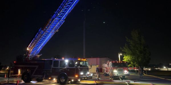 Fire trucks and firefighters working at night.