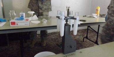 Military personnel and lab equipment on tables.