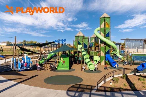 Large outdoor playground with slides and shade structures and children playing