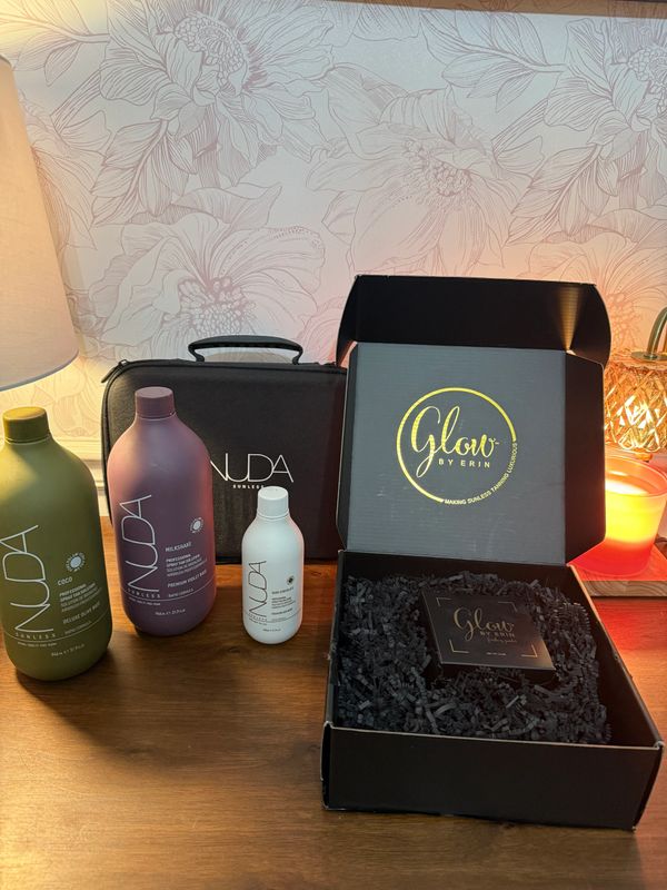 NUDA skincare products and Glow by Erin box displayed on a wooden table.