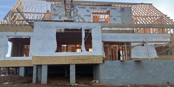 Wooden frame of a house under construction on a concrete foundation.