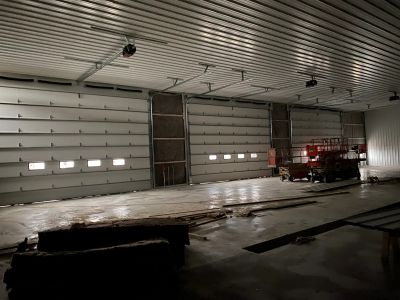 Interior of a large warehouse with closed garage doors.