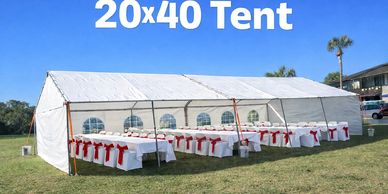 Large white 20x40 tent set up outdoors with tables and chairs.