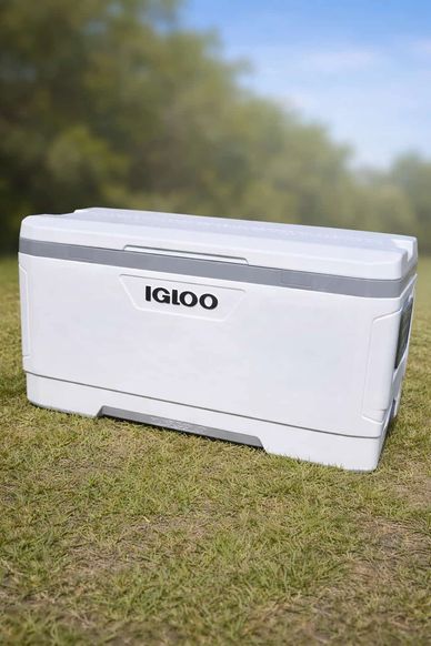 White Igloo cooler on grass with a blurred natural background.