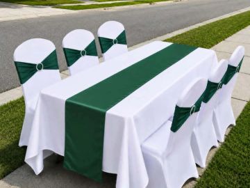 Outdoor table setup with white and green decorations.