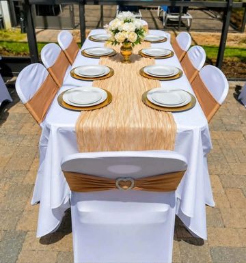 Elegant outdoor dining table setup with white and gold decor.