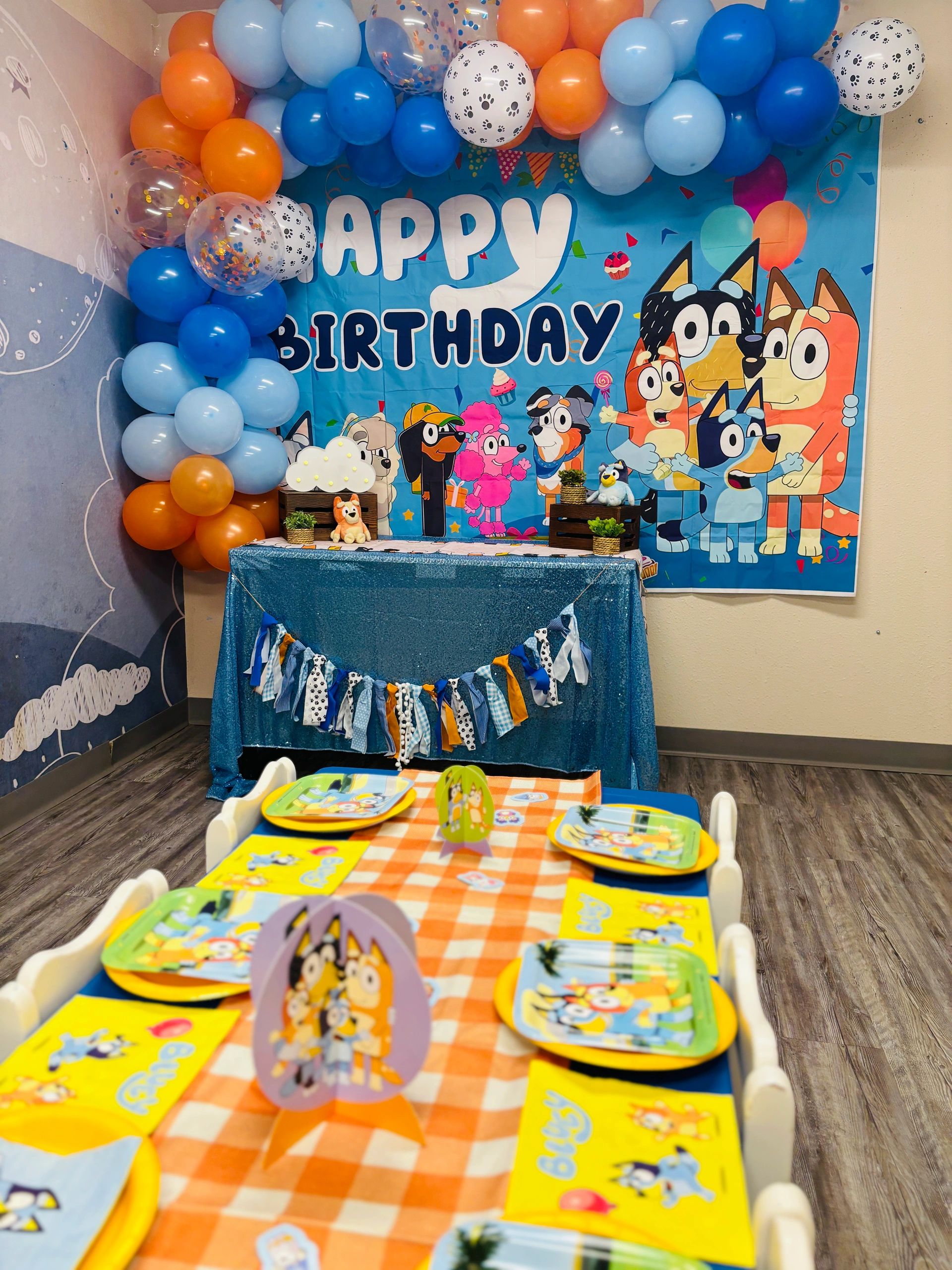 A Bluey birthday setup at Smarty Sprouts with a balloon garland and coordinated party table, showcasing Flower Full Themed Décor.