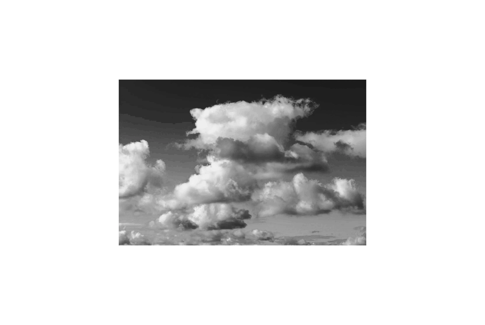 Black and white photo of fluffy clouds in the sky.