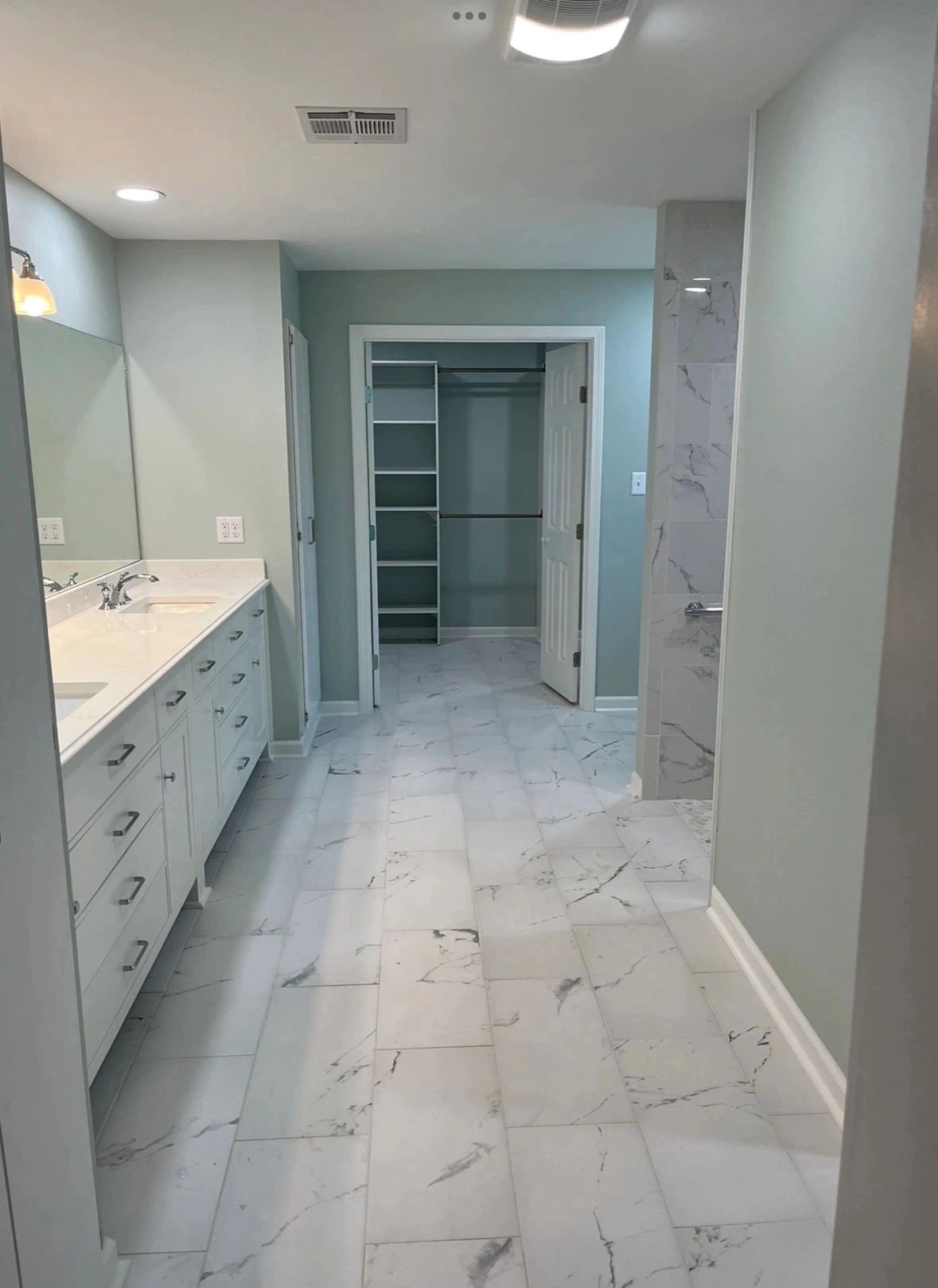 Bathroom Remodel with white marble tiles and a walk-in closet.