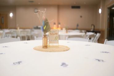 Decorated table with centerpiece and sign in event hall.