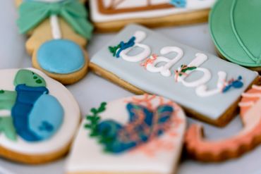 Close-up of decorated baby-themed cookies with pastel colors.
