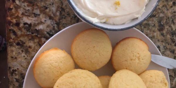 Plate of cookies with a bowl of cream on top.