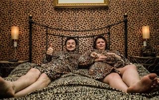 Couple reclining on bed in leopard-themed room at Hotel Pelirocco, Brighton