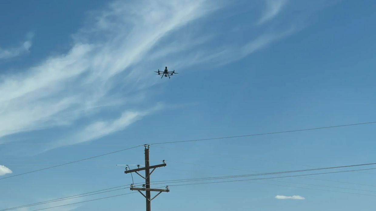 Drone inspecting electric distribution lines.