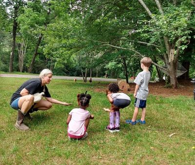 Farmer with children feeding chickens