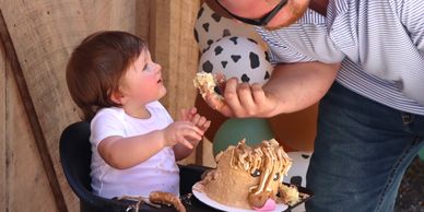 Child birthday party at a petting farm with boy eating cake 