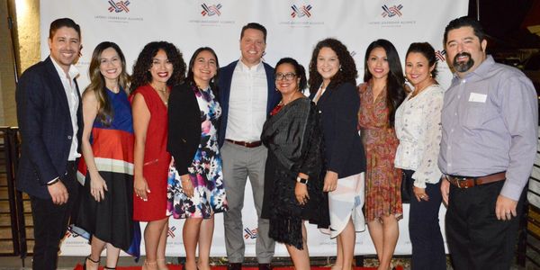 Group of ten diverse professionals posing at a formal event.