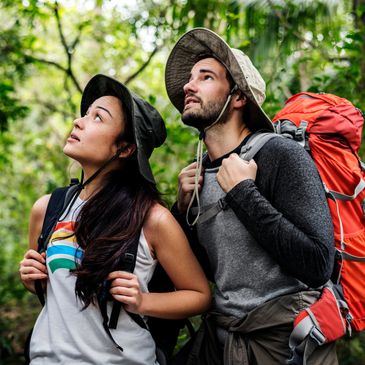 Two trekkers are looking up with their trekking bags inside the jungles of Belihuloya. 