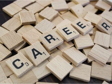 Scrabble tiles spelling "CAREER" among scattered blank tiles.
