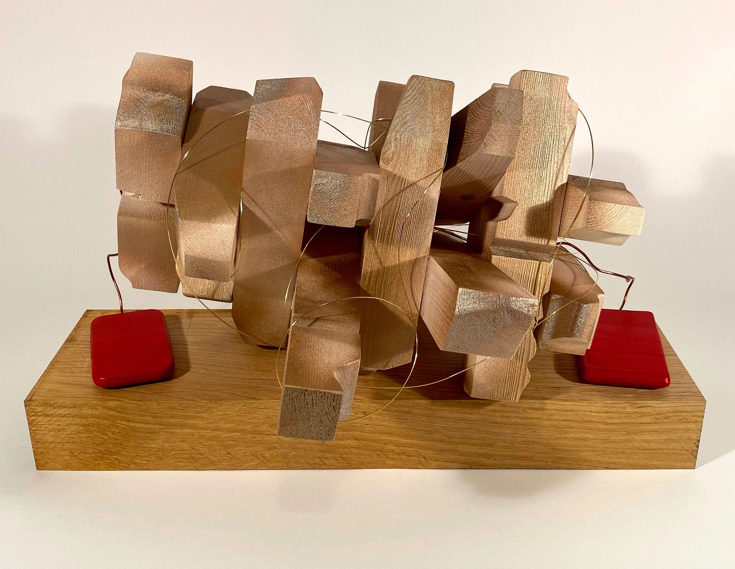 Abstract wooden sculpture with wire loops on a wooden base and red accents.