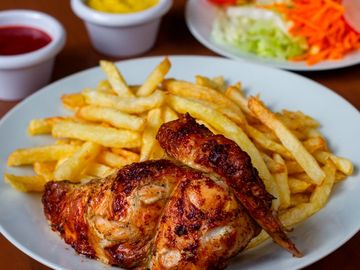 Grilled chicken quarter served with crispy French fries and dipping sauces.