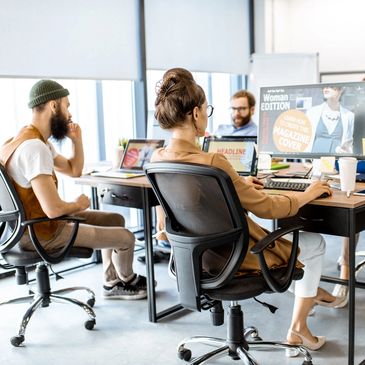 Creative team collaborating on magazine design in a modern office.
