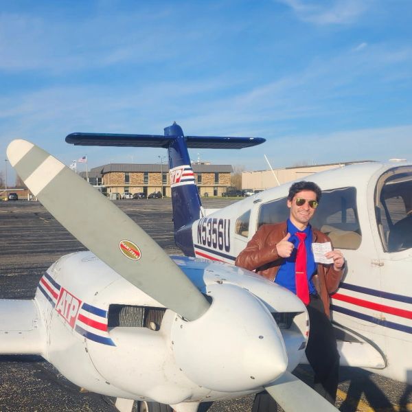 Man giving thumbs up by a small airplane.