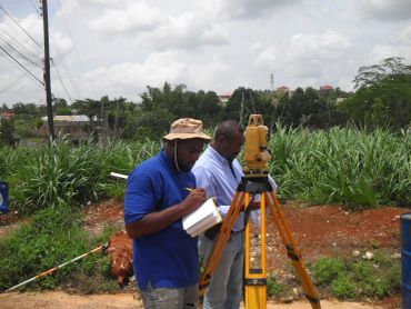 Two men conducting a land survey outdoors.
