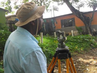 Surveyor working with a theodolite outdoors.
