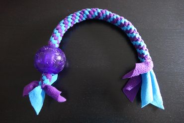 Purple and turquoise tug toy with a large purple ball at one end of the toy.