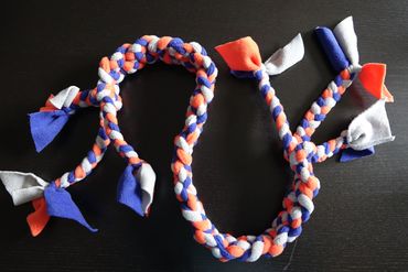 3 small plaits plaited together. Each plait made from 3 different colours. Blue, orange and grey.