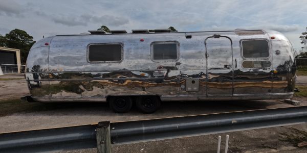 Shiny silver trailer parked outdoors.