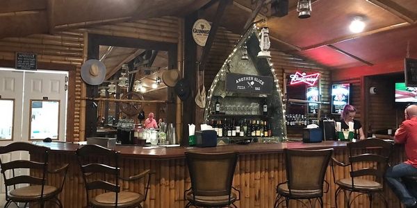 Cozy wooden bar with stools and a canoe-shaped liquor display.