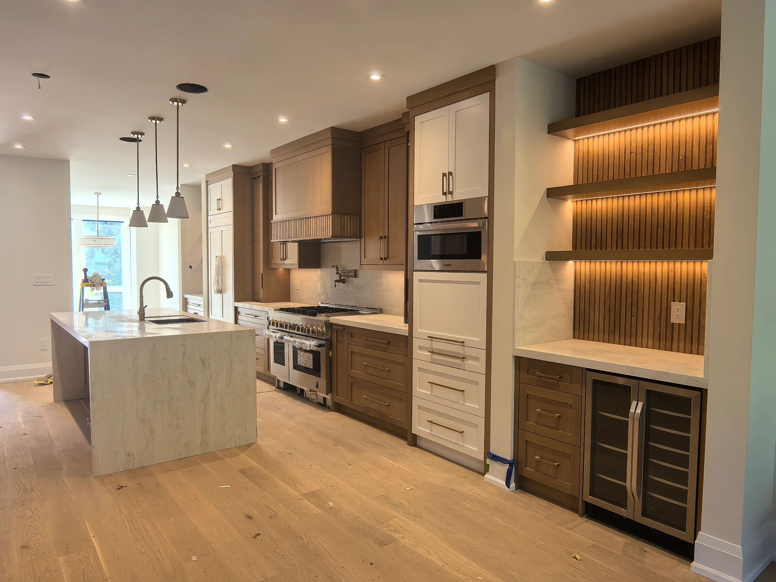 Modern kitchen with wooden cabinets and marble island.