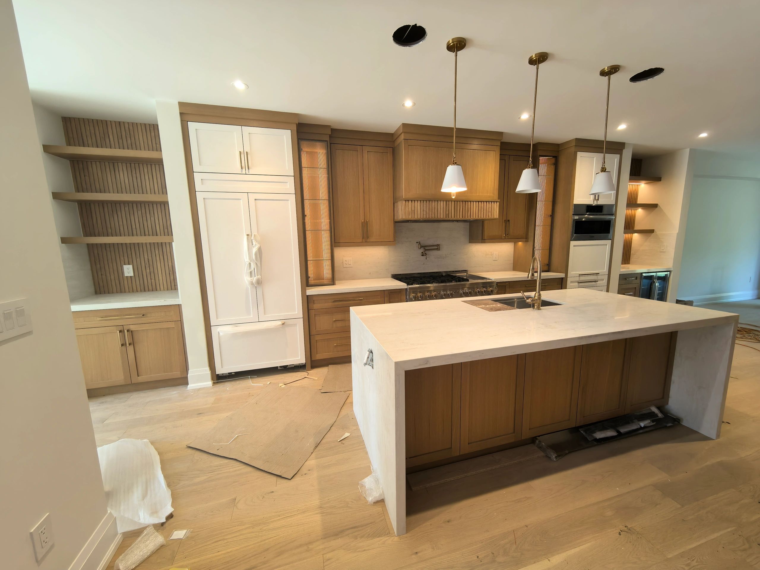 Modern kitchen with wooden cabinets and marble island.