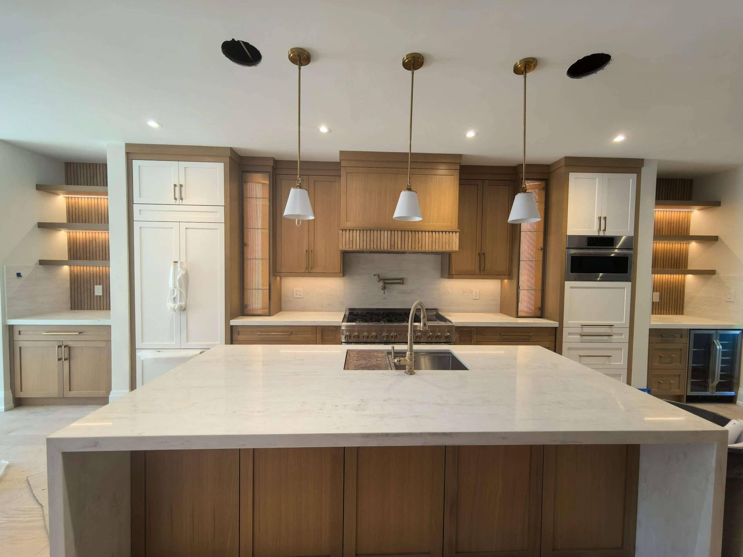 Modern kitchen with wooden cabinets and marble island.