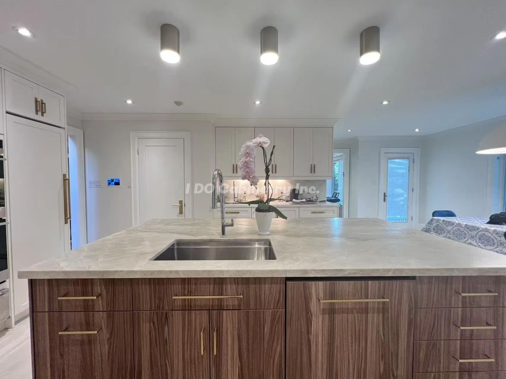 Modern kitchen with marble countertop and orchid centerpiece.