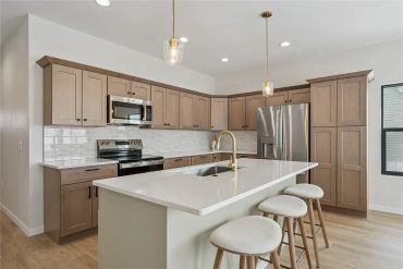 Modern kitchen with island and stools.
