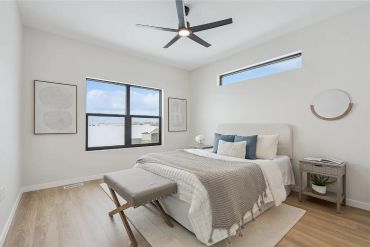 Bright bedroom with modern decor and large windows.